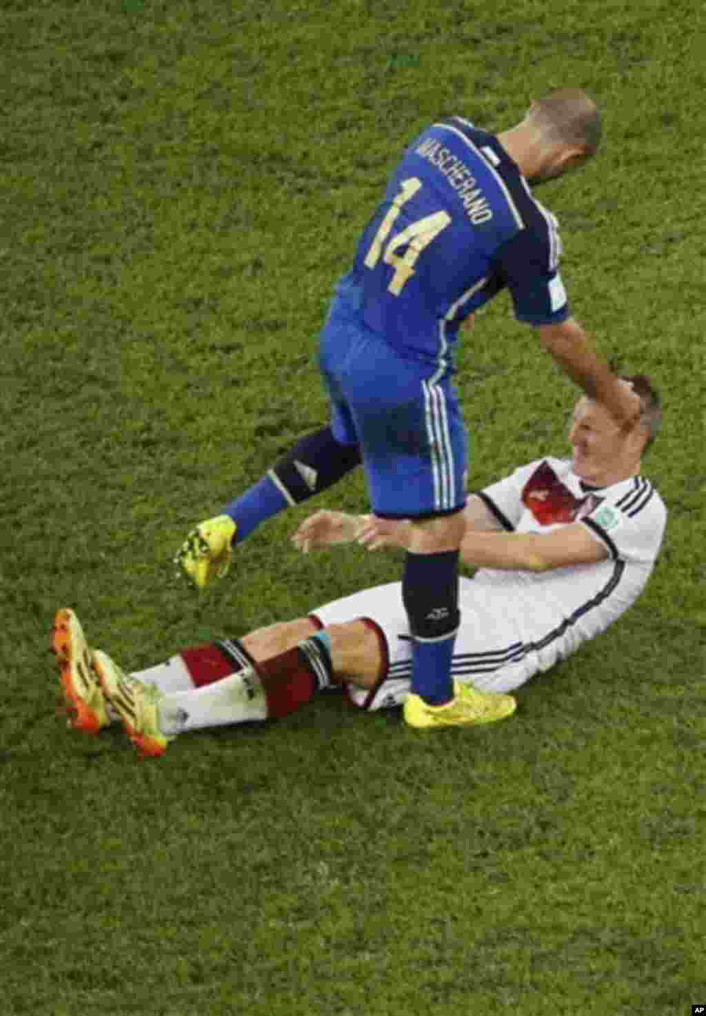 Argentina's Javier Mascherano helps Germany's Bastian Schweinsteiger up during the World Cup final soccer match between Germany and Argentina at the Maracana Stadium in Rio de Janeiro, Brazil, Sunday, July 13, 2014. (AP Photo/Fabrizio Bensch, Pool)