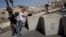 FILE - Israeli border police search a Palestinian next to newly placed concrete blocks in an East Jerusalem neighborhood, Oct. 15, 2015.