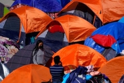 Tents used by migrants seeking asylum in the United States line an entrance to the border crossing, in Tijuana, Mexico, March 1, 2021.
