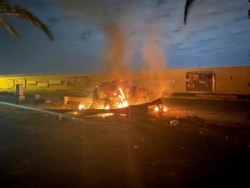 Burning debris are seen on a road near Baghdad International Airport, which according to Iraqi paramilitary groups were caused by three rockets hitting the airport in Iraq, January 3, 2020, in this image obtained via social media.