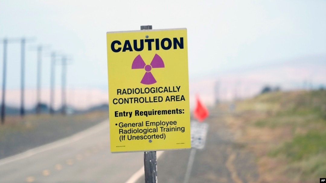 FILE - A caution sign stands on the Hanford Nuclear Reservation in the U.S. state of Washington, June 2, 2022. At least 12 workers at the site have been laid off as part of the Trump administration's downsizing of the federal workforce.