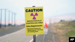 FILE - A caution sign stands on the Hanford Nuclear Reservation in the U.S. state of Washington, June 2, 2022. At least 12 workers at the site have been laid off as part of the Trump administration's downsizing of the federal workforce.