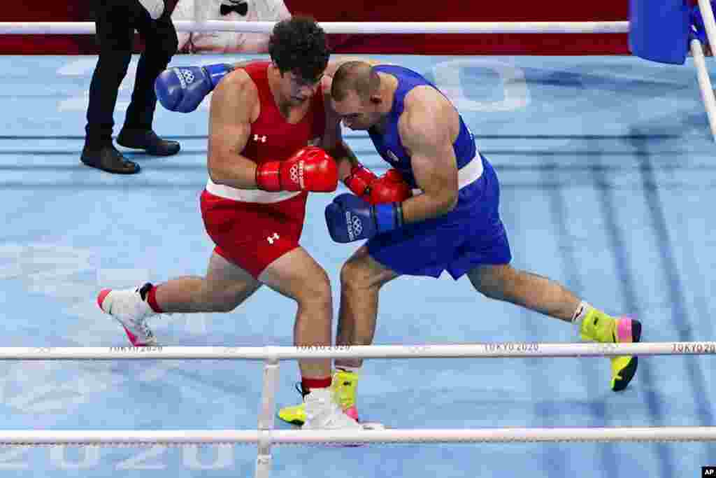 Richard Torrez Jr. from the United States, left, exchanges punches with Algeria&#39;s Chouaib Bouloudinats during their men&#39;s super heavyweight over 91-kg boxing match at the 2020 Summer Olympics, Thursday, July 29, 2021, in Tokyo, Japan. (AP Photo/Frank Franklin II)