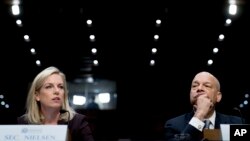 Homeland Security Secretary Kirstjen Nielsen, left, accompanied by former Homeland Security Secretary Jeh Johnson, right, testifies at a Senate Intelligence Committee hearing on election security on Capitol Hill in Washington, March 21, 2018.