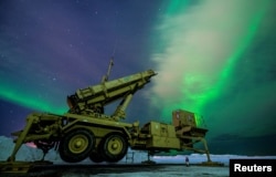 资料照片：在阿拉斯加州艾尔森空军基地的一次演习期间，北极光映衬着一部M903爱国者导弹发射车。(2022年3月5日)