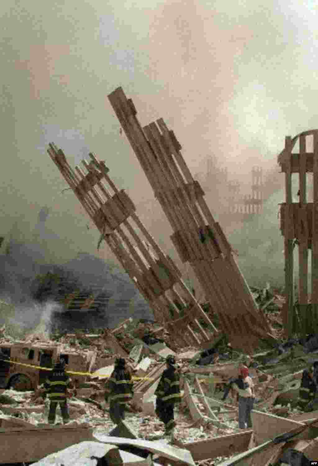 Firefighters work in the rubble of the World Trade Center towers in New York, Wednesday, Sept. 12, 2001. The towers collapsed Tuesday after being struck by two commercial aircrafts in a terrorist attack. (AP Photo/Virgil Case)