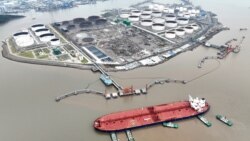 资料照片：在中国浙江省舟山市外海，航拍画面显示，几艘拖船正在协助一艘原油油轮在石油码头靠泊。(2022年7月18日)