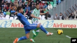 Rubén Castro du Betis Séville, à droite, essaie de bloquer un contrôle de Sergio Ramos du Real Madrid lors d’un match de la Liga au stade de Séville, Espagne, 18 janvier 2014.