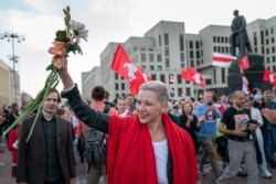 FILE - Belarusian opposition activist Maria Kolesnikova greets protesters during a rally at Independence Square in Minsk, Belarus, Aug. 22, 2020.