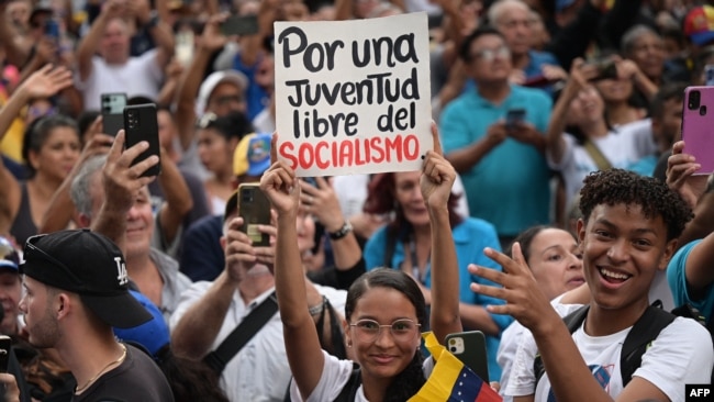 Un partidario del candidato presidencial de la oposición venezolana, Edmundo González, sostiene un cartel que dice "por una juventud libre del socialismo" durante una manifestación en Caracas el 4 de julio de 2024.
