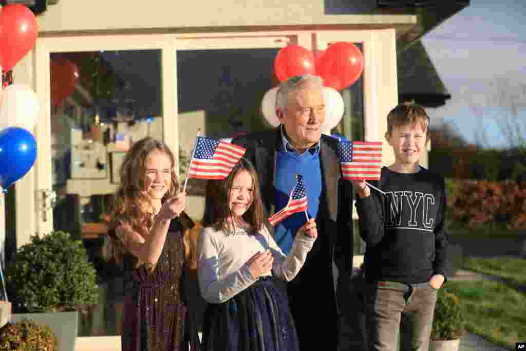 Joe Biden&#39;s cousin Brendan Blewitt with his grandchildren Emily, Lauren, and Darragh wave their U.S. flags to the media from their home in Knockmore, near the town of Ballina in Ireland.