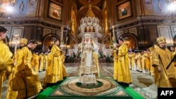 This handout photograph taken and released by Russian Orthodox Church Press Service on Jan. 7, 2025, shows Russia's Orthodox Patriarch Kirill, center, leading an Orthodox Christmas Service at the Cathedral of Christ the Saviour in Moscow. 