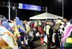 FILE - Venezuelans gather to cross into Ecuador from Colombia, as new visa restrictions from the Ecuadorian government took effect, at the Rumichaca border bridge in Tulcan, Ecuador, Aug. 26, 2019.