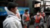 South Korean soldiers in protective gear talk as they disinfect on the street as a precaution against the new coronavirus in Seoul, South Korea, March 12, 2020. 