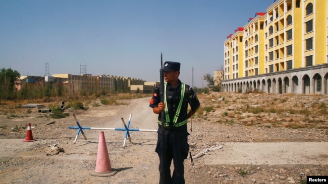 资料照片:中国警察在新疆伊宁一处官方所说的职业教培中心附近的路口站岗。(2018年9月4日)