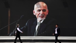 FILE - In this Aug. 14, 2021 file photo, a mural of Afghan President Ashraf Ghani hangs at Hamid Karzai International Airport, in Kabul, Afghanistan.