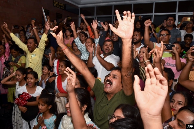 People celebrate the successful landing of Chandrayaan-3 spacecraft on the Moon, at Guwahati Planetarium in Guwahati on August 23, 2023. (Photo by Biju BORO / AFP)