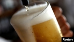 FILE - A pint of beer is poured into a glass in a bar in London, Britain, June 27, 2018.