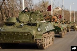 FILE - Pro-Russia rebels are seen driving in a convoy in Stakhanov, eastern Ukraine, April 24, 2015. Meeting Tuesday in Sochi, Russian President Vladimir Putin and German Chancellor Angela Merkel continued to disagree on the causes of the conflict in eastern Ukraine.