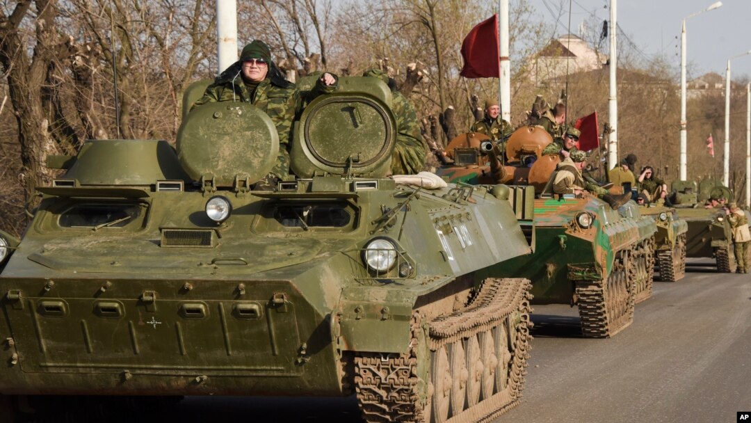 FILE - Pro-Russia rebels are seen driving in a convoy of armored vehicles and tanks in Stakhanov, eastern Ukraine, April 24, 2015. 