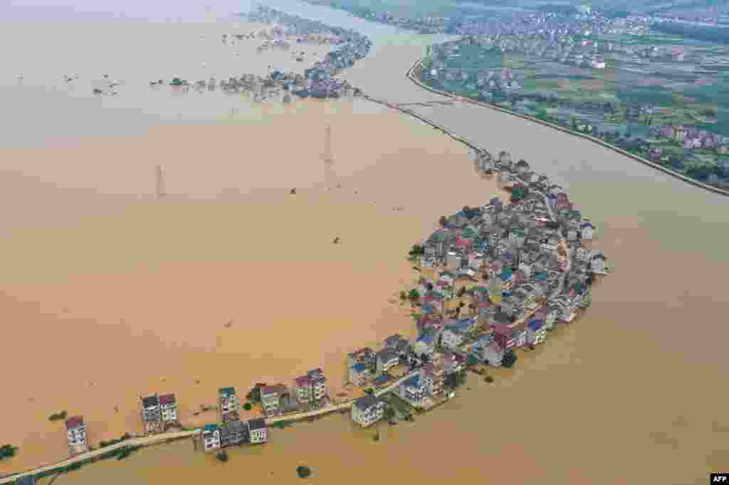 This aerial view shows submerged streets and inundated buildings after a dam was breached due to flooding in Jiujiang in China&#39;s central Jiangxi province.