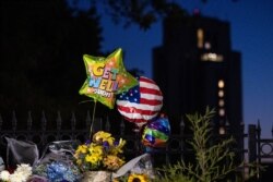 Flores y globos dejados por partidarios del presidente Donald Trump a la entrada del Centro Médico Militar Walter Reed, en Bethesda, Maryland, el domingo 4 de octubre de 2020.