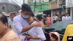 3일 정치범 사면을 통해 미얀마 양곤 인세인 교도소에서 풀려난 수감자(가운데 왼쪽)가 어머니와 포옹하고 있다. 