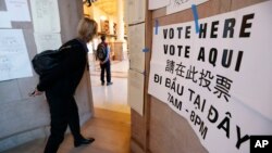 Người dân đi bầu tại một thư viện ở Boston, Massachusetts, 8/11/2016. Tiếng Việt là một trong bốn ngôn ngữ được in trên bảng hướng dẫn dán bên ngoài phòng phiếu.