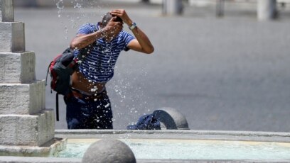 Một người đàn ông giải nhiệt tại đài phun nước ở trung tâm của Rome, Ý, ngày 25 tháng 6, 2019