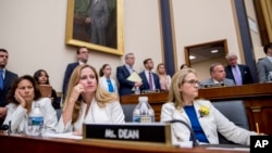 From left, Rep. Veronica Escobar, D-Texas, Rep. Debbie Mucarsel-Powell, D-Fla., and Rep. Madeleine Dean, D-Pa., wear white and yellow roses to commemorate the 19th Amendment on Capitol Hill in Washington, Tuesday, May 21, 2019.