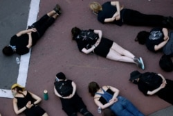 FILE - Protesters block a downtown Kansas City, Mo. intersection, July 17, 2020. Demonstrators were demanding police reforms and an end to Operation Legend, a federal initiative that will deploy 225 federal agents to fight crime in the city.