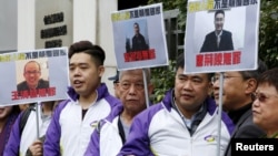 Members from Civic Party, holding portraits of (L-R) Wang Qingying, Yuan Chaoyang and Tang Jingling, protest outside China's Liaison Office in Hong Kong, China, Jan. 29, 2016.