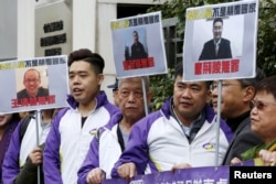 Members from Civic Party, holding portraits of (L-R) Wang Qingying, Yuan Chaoyang and Tang Jingling, protest outside China's Liaison Office in Hong Kong, China, Jan. 29, 2016.