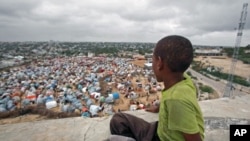 A boy sits looking over the Seyidka settlement for the famine stricken internally displaced people in Berkulan near Somalia's capital, Mogadishu, September 6, 2011.