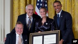 El ex presidente Bush y el presidente Obama entregan el premio 5.000 del programa de voluntarismo Daily Point of Light a Floyd Hammer y Kathy Hamilton.