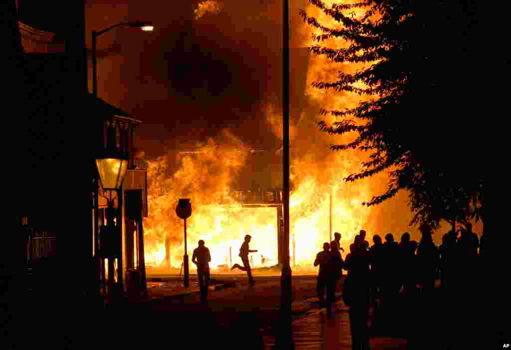 A shop is set on fire as rioters gather in Croydon, south London, England, Aug. 8, 2011. Protests in London broke out against planned public spending cuts by the government. (AP)