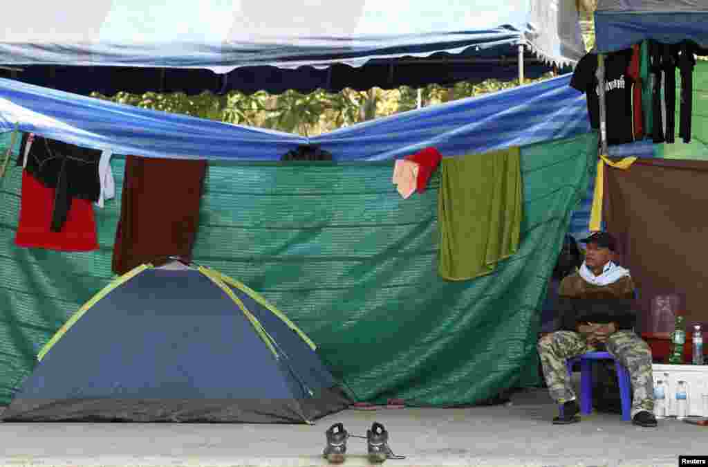 An anti-government protester takes a rest beside his tent during a rally near the Government Complex in Bangkok, Jan. 24, 2014.