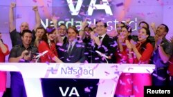 David Cush, third left front row, President & CEO of Virgin America is applauded and showered with confetti as he rings the opening bell at the Nasdaq MarketSite, to mark his company's IPO, in New York, Nov. 14, 2014. 