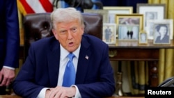 President Donald Trump looks on as he signs an executive order in the Oval Office at the White House in Washington, Jan. 31, 2025. 