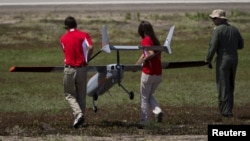 The FireFlight UAS TwinHawk is carried to the runway during Black Dart, a demonstration of 55 unmanned aerial vehicles, or drones, at Naval Base Ventura County Sea Range, Point Mugu, near Oxnard, Calif., July 31, 2015. 