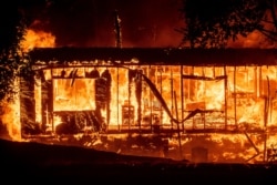 Flames consume a home as the Kincade Fire tears through the Jimtown community of Sonoma County, Calif., on Oct. 24, 2019.