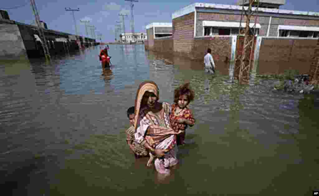 A woman carries her child while escaping to higher ground from her flooded village in the Mirpur Khas district of Pakistan's Sindh province, September 15, 2011. (Reuters)