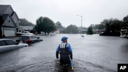 A member of the North Carolina Task Force urban search and rescue team wades through a flooded neighborhood looking for residents who stayed behind as Florence continues to dump heavy rain in Fayetteville, N.C., Sunday, Sept. 16, 2018.