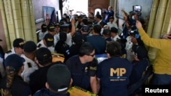 Miembros del Ministerio Público de Guatemala cargan cajas con boletas electorales durante un allanamento en el Supremo Tribunal Electoral en la Ciudad de Guatemala el 30 de septiembre de 2023.