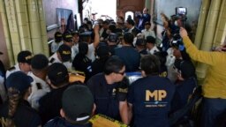 Miembros del Ministerio Público de Guatemala cargan cajas con boletas electorales durante un allanamento en el Supremo Tribunal Electoral en la Ciudad de Guatemala el 30 de septiembre de 2023.