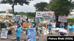 Aksi Kelompok River Warrior di depan kantor Konjen Amerika Serikat di Surabaya, menolak sampah plastik Amerika Serikat di Indonesia. (Foto: VOA/Petrus Riski)