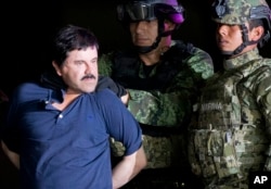FILE - Joaquin "El Chapo" Guzman is escorted to a helicopter by Mexican soldiers and marines at a federal hangar in Mexico City, Jan. 8, 2016.