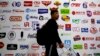 FILE - a man walks by a billboard displaying a Chinese company developed packaging machinery for local and foreign food and beverage companies at the International soybean exhibition in Shanghai. 