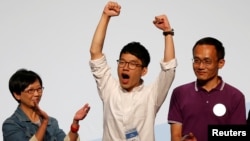 Student leader Nathan Law (C) celebrates on the podium after his win in the Legislative Council election in Hong Kong, China, Sept. 5, 2016. 
