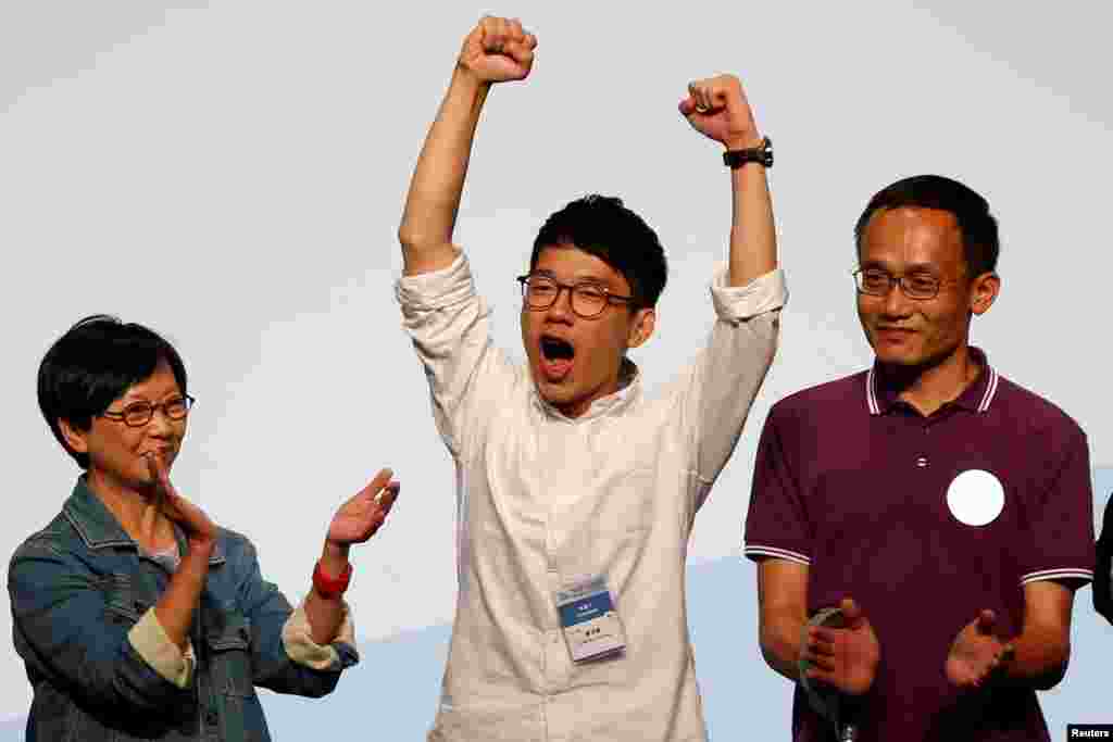 មេដឹកនាំនិស្សិត Nathan Law (កណ្តាល) ធ្វើការអបអរសាទរលើឆាក បន្ទាប់ពីទទួលបានជ័យជម្នះក្នុងការបោះឆ្នោតក្រុមប្រឹក្សានីតិបញ្ញត្តិក្នុងកោះហុងកុង ប្រទេសចិន។ 